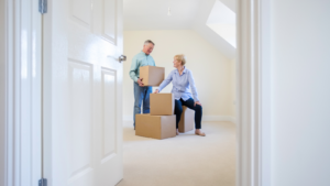 A couple with boxes stacked up in an empty room