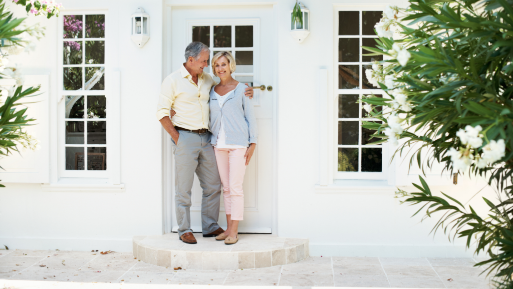 a couple standing in front of a door of a house