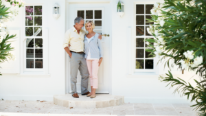 a couple standing in front of a door of a house