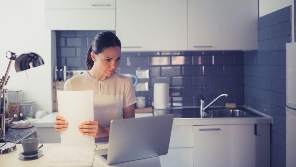 woman looking at paperwork in the kitchen