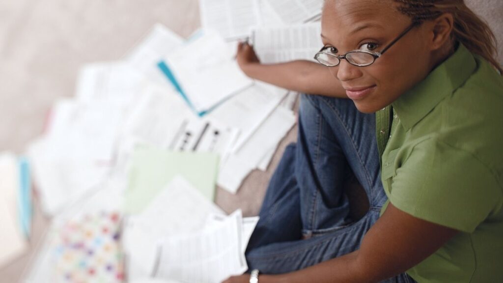 woman with paperwork looking up at the camera