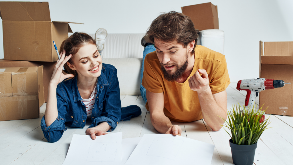 A man and a woman looking at a list and seeming excited and surrounded by boxes and tools