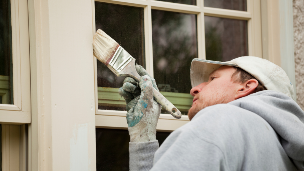 Man painting some exterior trim of a home